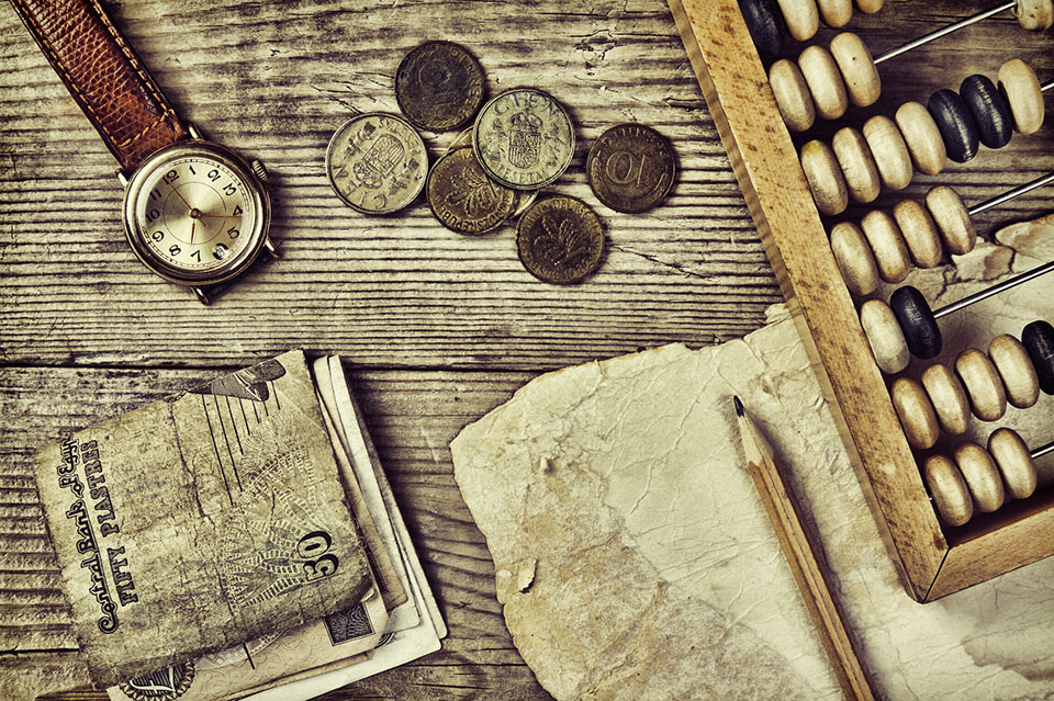 Old notes and coins and abacus on a wooden table